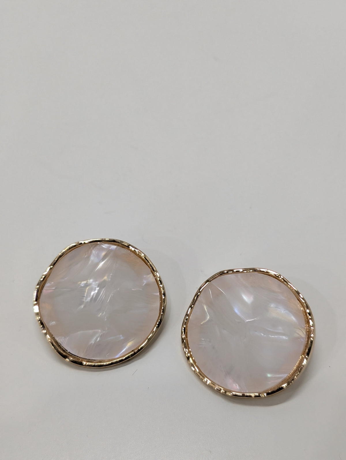 Pair of round stud earrings with textured gold-tone rims and smooth iridescent off-white centres