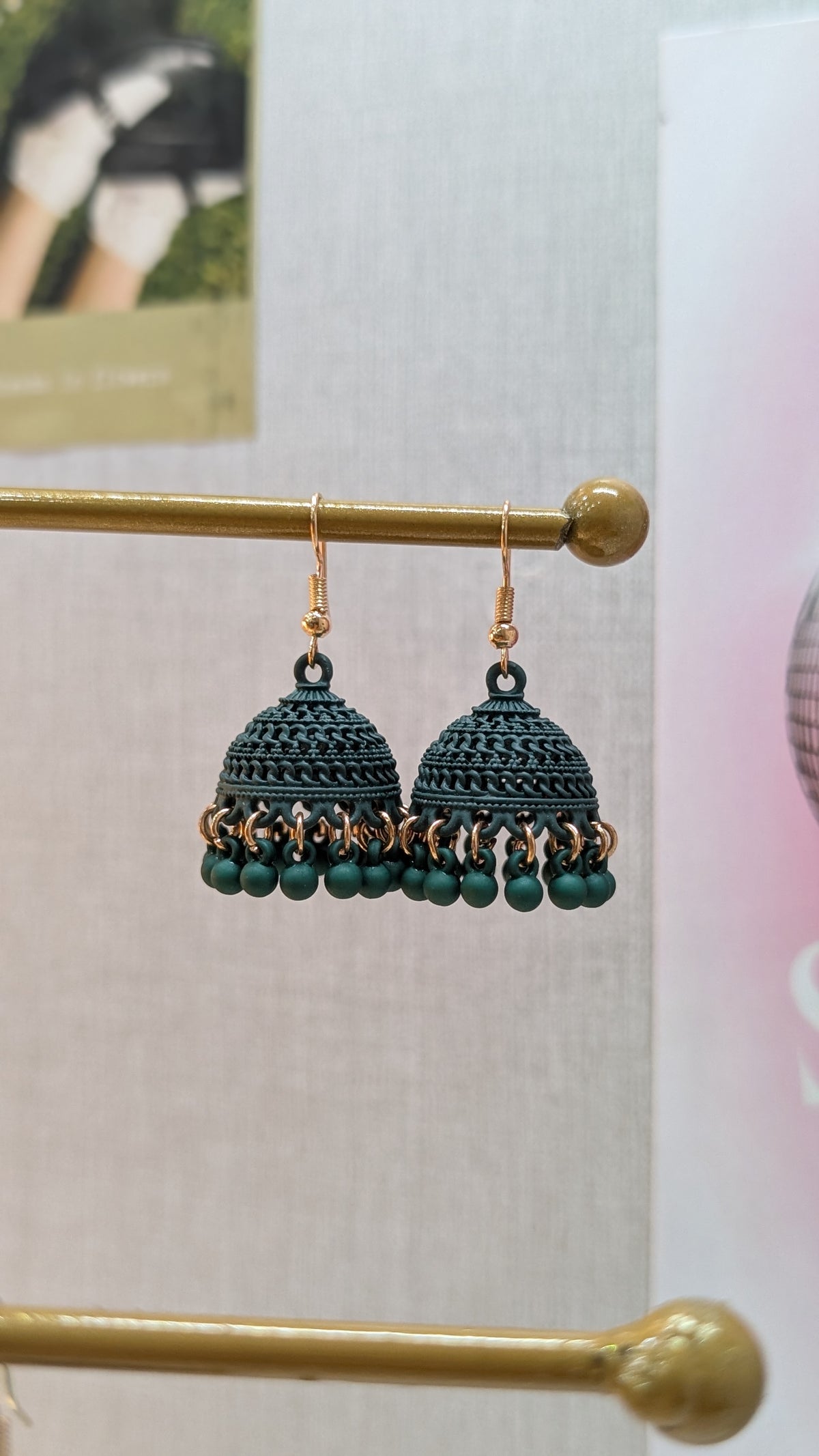 Dark green dome-shaped dangle earrings with gold-tone hooks and a fringe of small dark green beads along the bottom.
