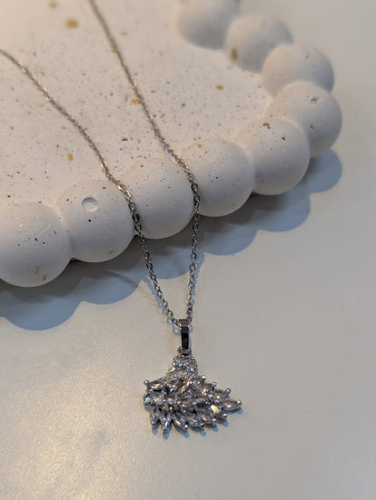 A silver-tone chain necklace with a pendant made of clustered clear, faceted stones in an abstract, spiky design.