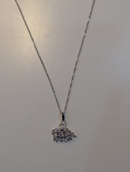 Silver-tone necklace with a fine chain and a swan pendant decorated with small clear sparkling accents and a fan-shaped tail.